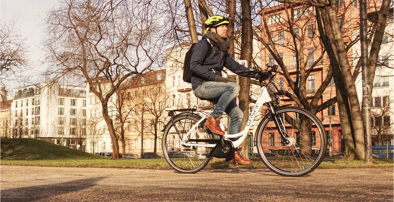 Mann auf E-Bike fährt durch Stadt