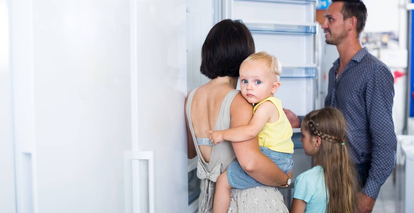 Eine Familie kauft einen energiesparenden Kühlschrank und informiert sich über das neue EU-Energielabel