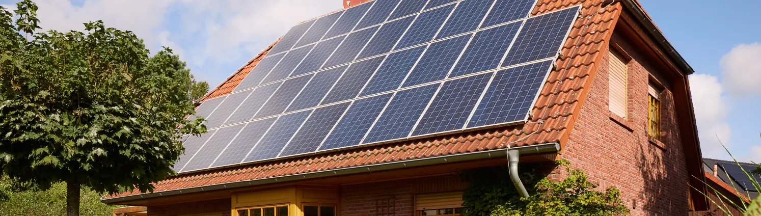 Schwarze Solarpanele auf dem Dach eines Einfamilienhauses