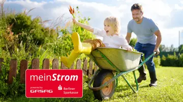 Ein Mann schiebt ein Kind in einer Schubkarre, auf dem Bild befindet sich das Logo der Aktion meinStrom