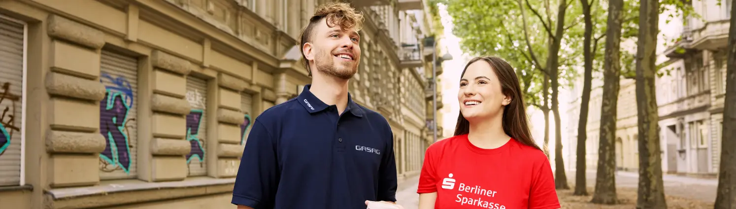 Eine Kollegin der Berliner Sparkasse und ein Kollege der GASAG stehen in den Berliner Straßen und quatschen