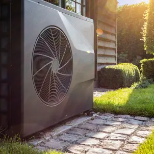 Nahaufnahme der schwarzen Vollinverter-Wärmepumpe draußen im Garten