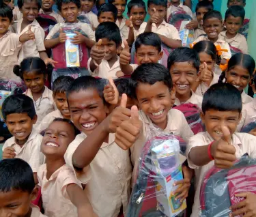 Mehrere Kinder aus Ramnad lächeln in die Kamera und sehen glücklich aus.