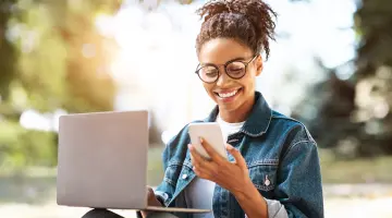 Eine Frau mit Brille schaut auf ihrem Smartphone
