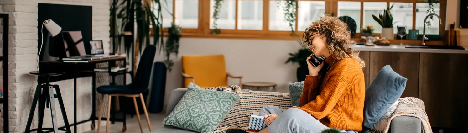 Eine Frau telefoniert auf einem Sofa