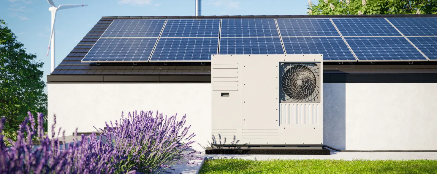 Eine auf dem Dach eines Einfamilienhauses installierte Wärmepumpe mit Photovoltaik-Paneelen