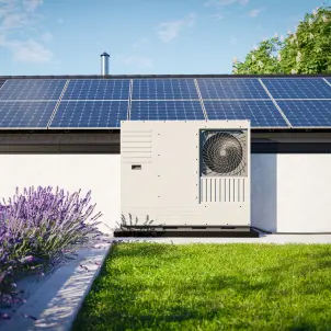 Eine auf dem Dach eines Einfamilienhauses installierte Wärmepumpe mit Photovoltaik-Paneelen