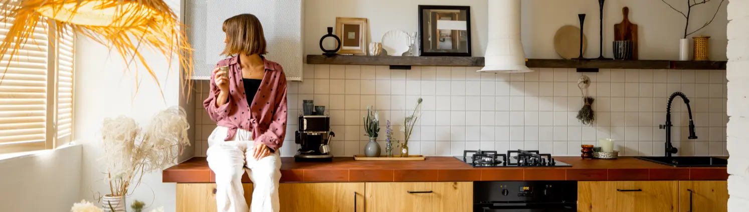 Modernes Kücheninterieur mit Person, die auf der Tischplatte sitzt