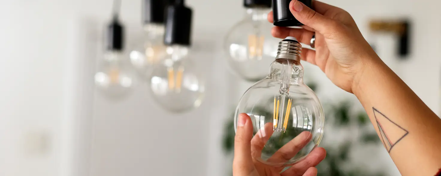 Frau, die energieeffiziente Glühbirnen installiert