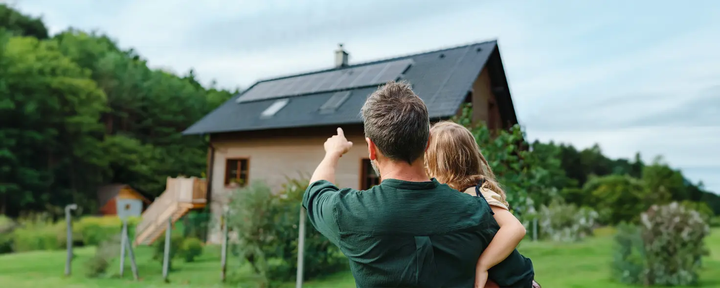 Mann zeigt Kind ihre Photovoltaik-Anlage auf dem Dach