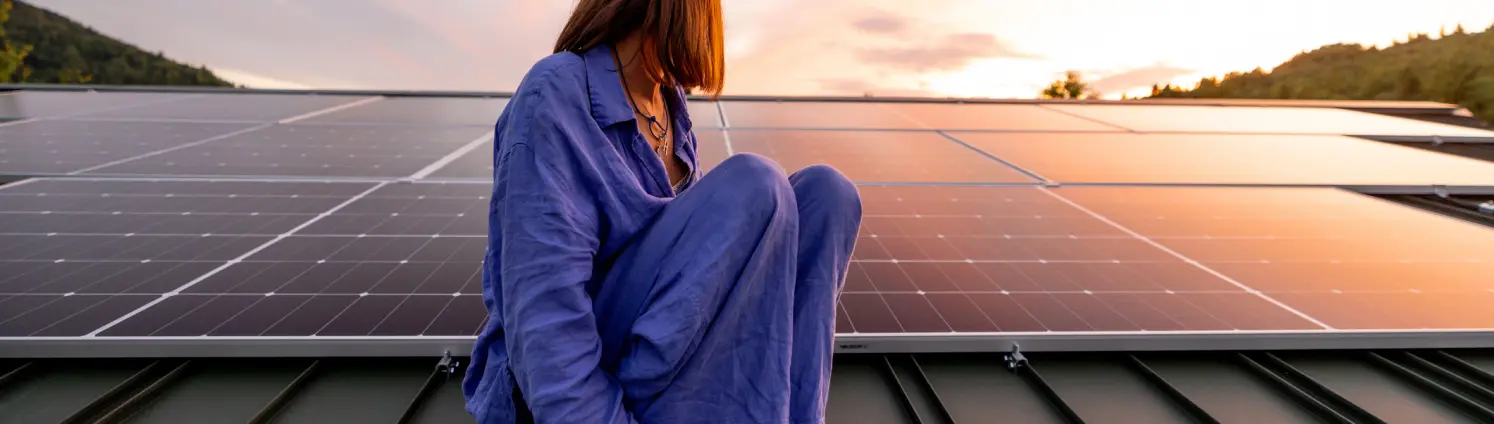 Frau sitzt auf Photovoltaik Anlage