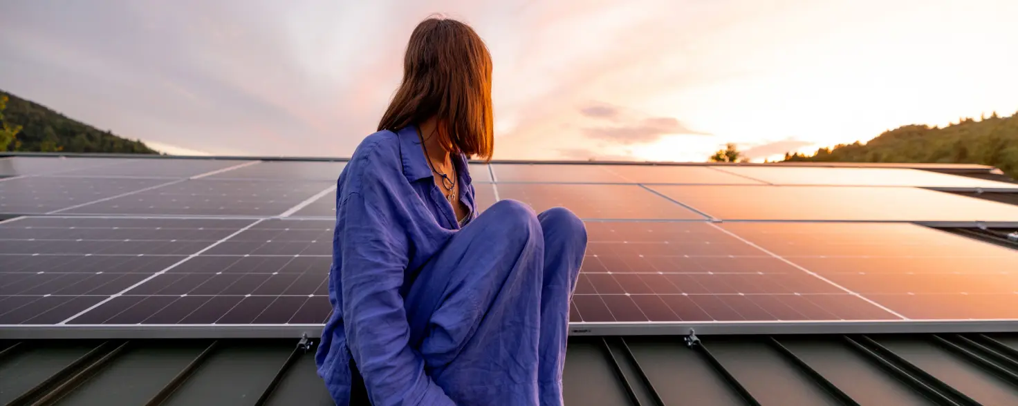 Frau sitzt auf Photovoltaik Anlage