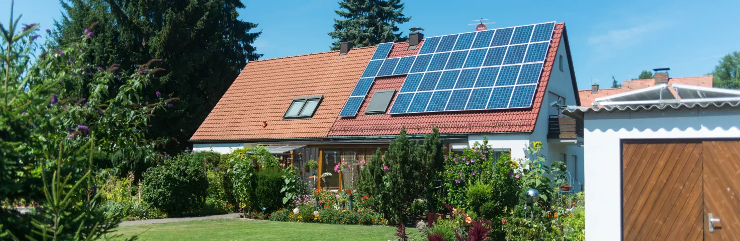 Ein Einfamilienhaus mit Photovoltaik-Modulen auf der einen Hälfte des Daches