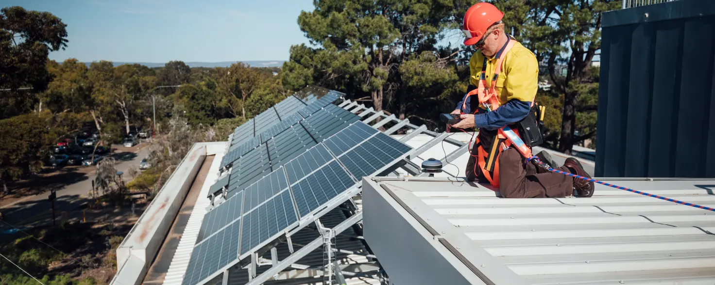 Ein Mann wartet eine Solaranlage auf einem Dach