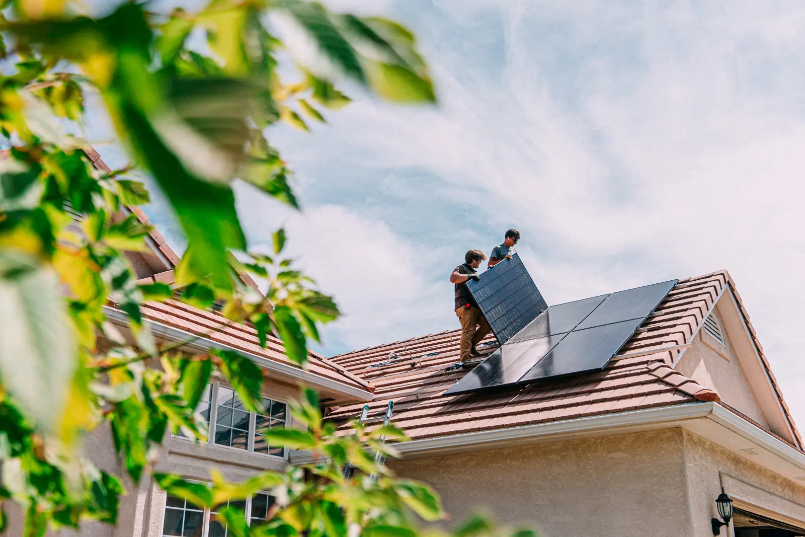 Junge Hausbesitzer installieren Solarmodule auf einem Haus