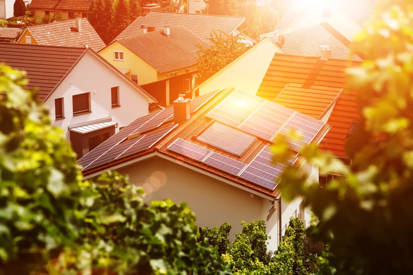 Haus von oben umgeben von Bäumen und Sonnenschein mit Solarthermie auf dem Dach