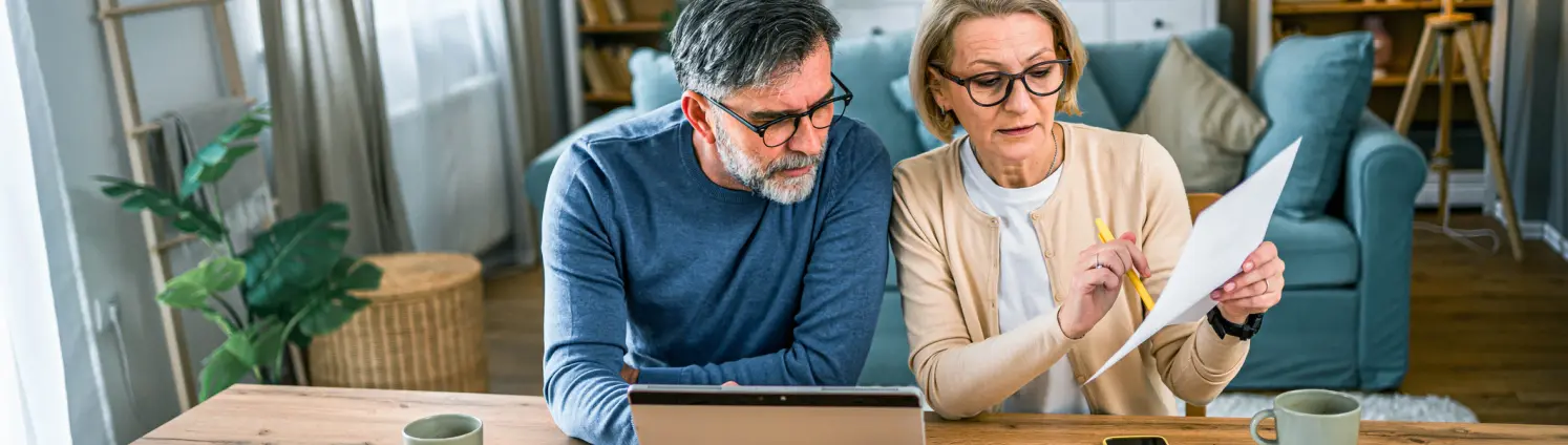 Ein älteres Paar schaut gemeinsam auf ein Dokument.