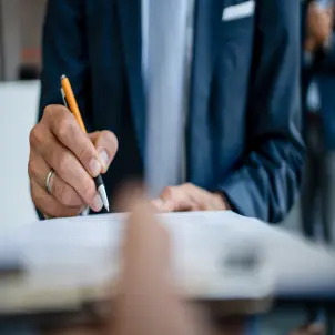 Ein Mann unterschreibt ein Dokument